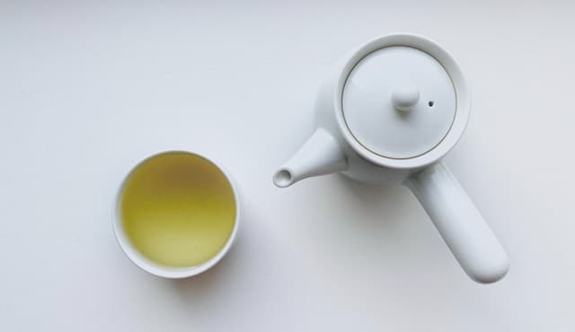 White ceramic teapot beside white ceramic mug